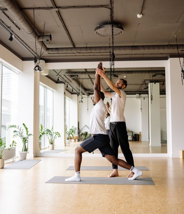 Man performing a controlled strength exercise in a well-lit studio.